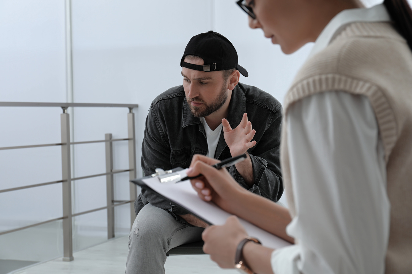 Psychotherapist Working with Drug Addicted Young Man Indoors