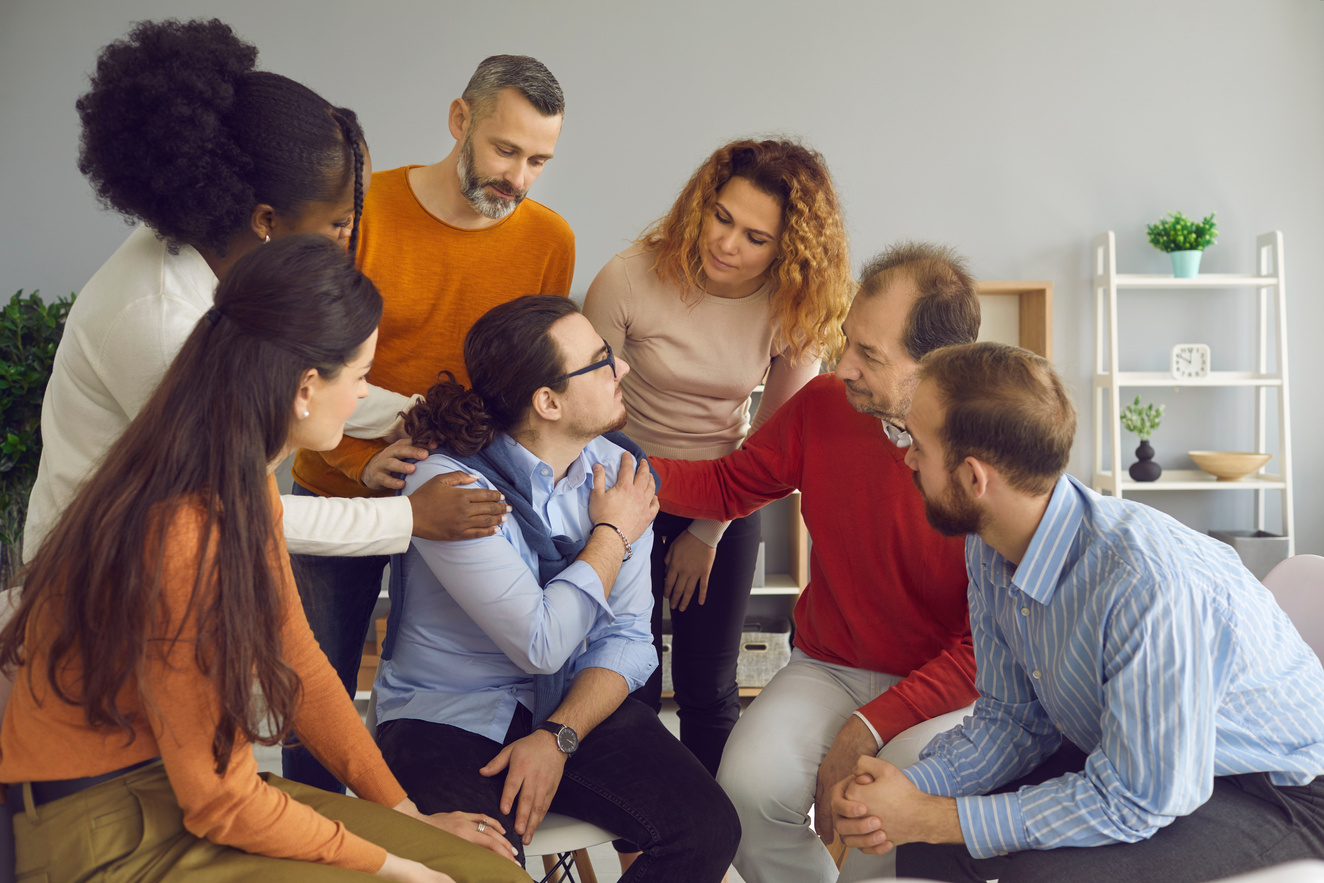 Young Patient Accepting Help from Diverse Men and Women in a Group Therapy Session